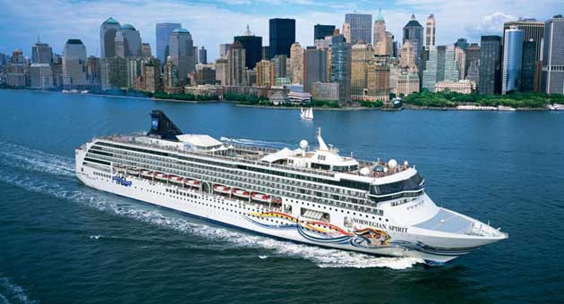 Travel X A Travel X cruise ship sails near a city skyline with numerous tall buildings under a partly cloudy sky, offering the perfect vacation vibe. Book Your Trip With Travel X