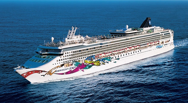 Travel X A large white cruise ship with colorful artwork on its side sails through the ocean, offering a dream vacation experience. Book your trip now and enjoy the ultimate floating resort. Book Your Trip With Travel X