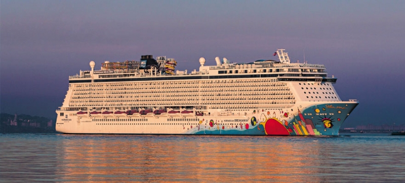 Travel X A large cruise ship with colorful artwork on its bow sails on calm water under a purple-tinged sky, offering a resort-like experience. Travel X invites you to book your trip and discover unmatched luxury on the high seas. Book Your Trip With Travel X