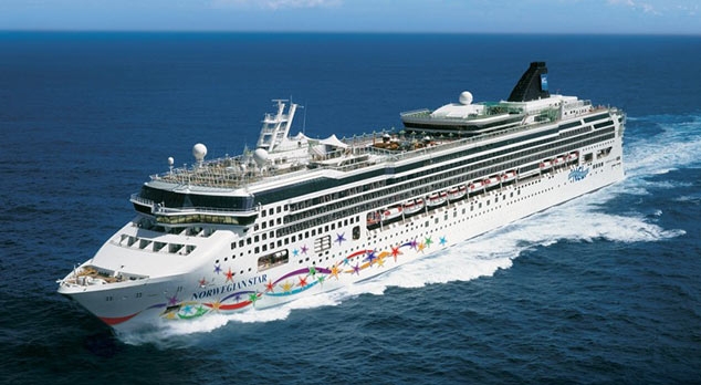 Travel X A white cruise ship adorned with colorful designs sails on a calm blue sea under clear skies, inviting you to Book Your Trip with Travel X. Book Your Trip With Travel X