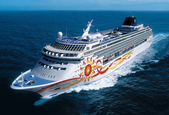 Travel X A large, decorated cruise ship sails on the open sea under a clear blue sky, offering the perfect vacation getaway. Book your trip now and experience this floating resort like never before! Book Your Trip With Travel X